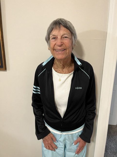 Joan Folpe portrait. She is smiling and dressed in an athletic pantsuit